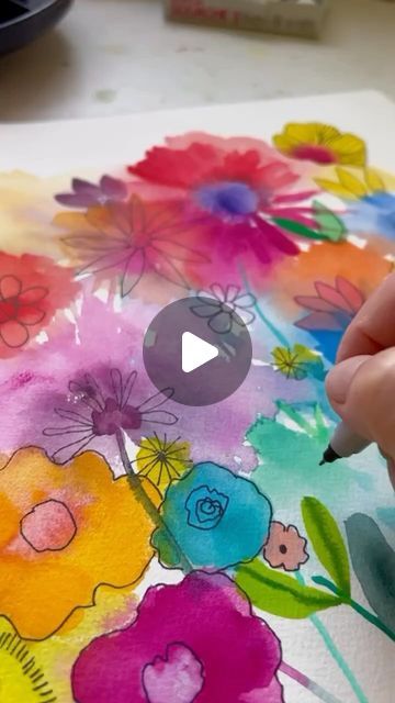 someone is painting flowers with watercolors on paper