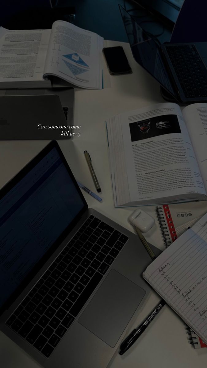 an open laptop computer sitting on top of a desk next to notebooks and papers