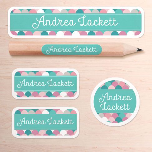 personalized name stickers and pencil on a wooden surface