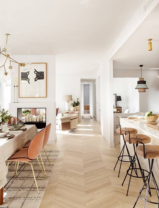 a dining room and kitchen area with wood flooring, white walls and wooden floors