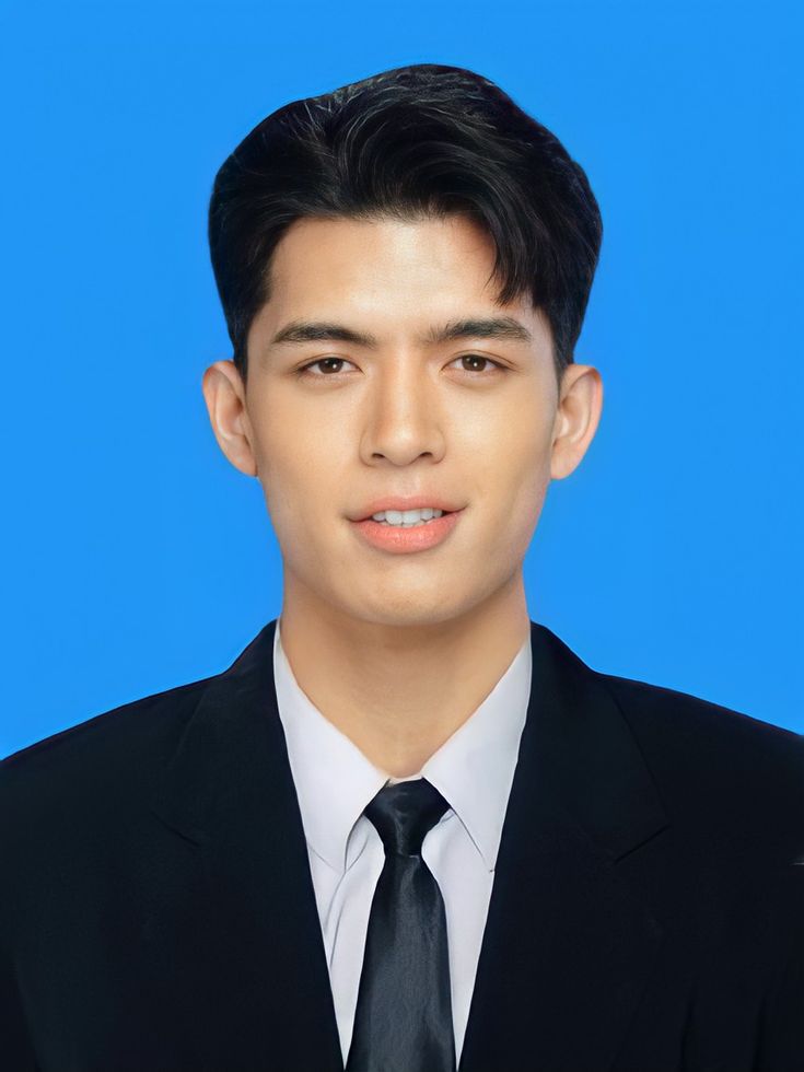 a young man in a suit and tie posing for a photo against a blue background