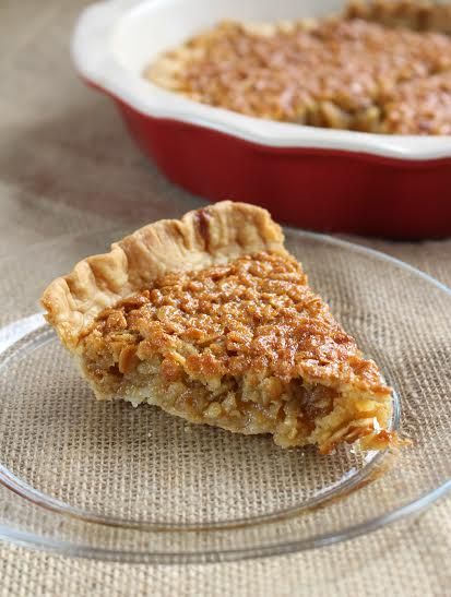 a piece of pie sitting on top of a glass plate next to a red casserole dish