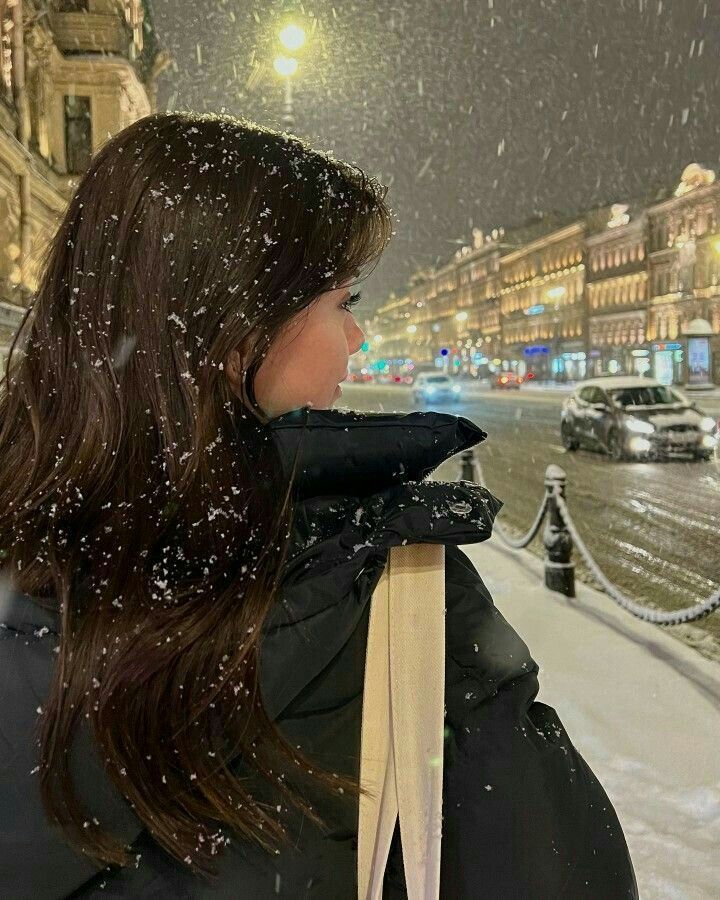 a woman standing in the snow with her back to the camera