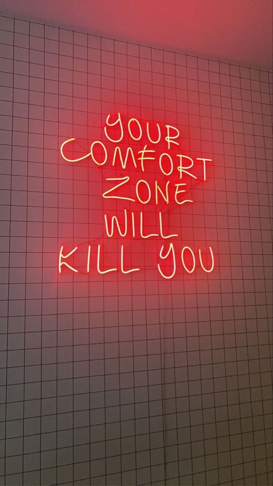 a red neon sign that says your comfort zone will kill you on the side of a wall