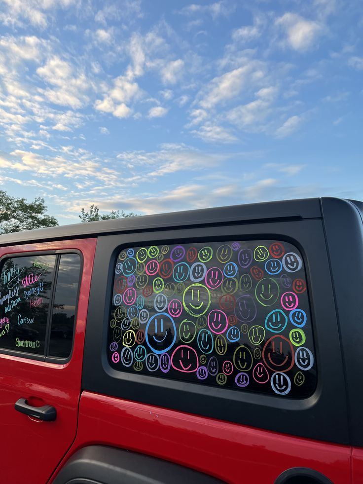 the back window of a red car with stickers on it