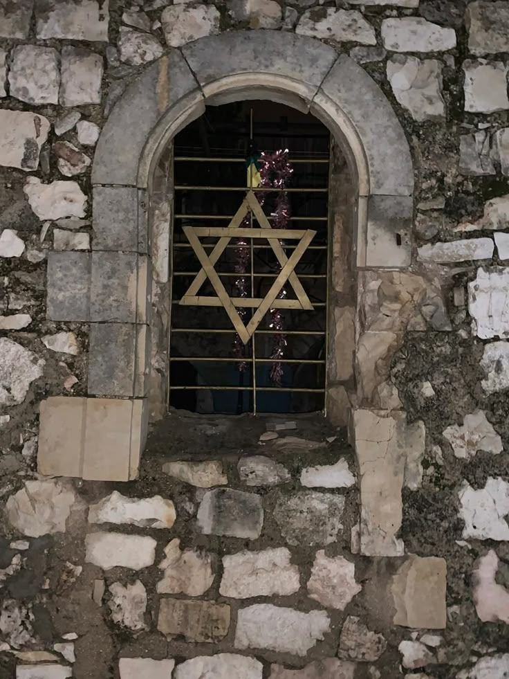 an old stone building with a star of david on the window and bars in it