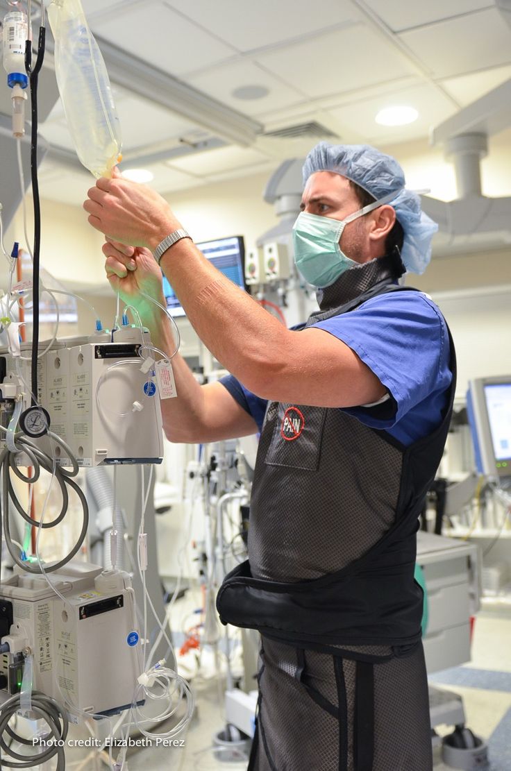 a man in scrubs is operating on an iv unit with medical equipment around him