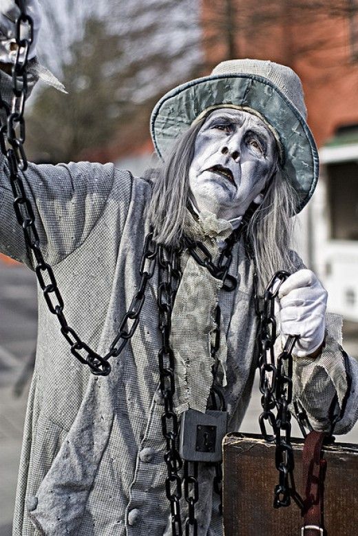 a man dressed as a witch with chains around his neck