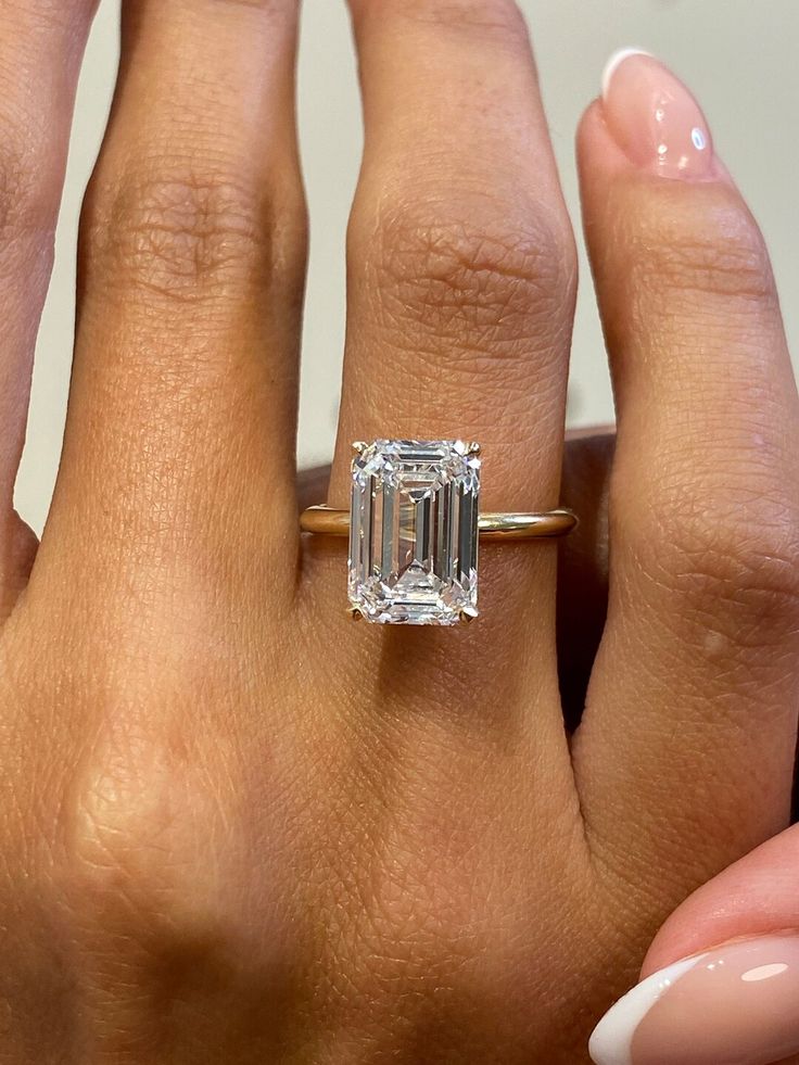 a woman's hand with a ring on it and a diamond in the middle