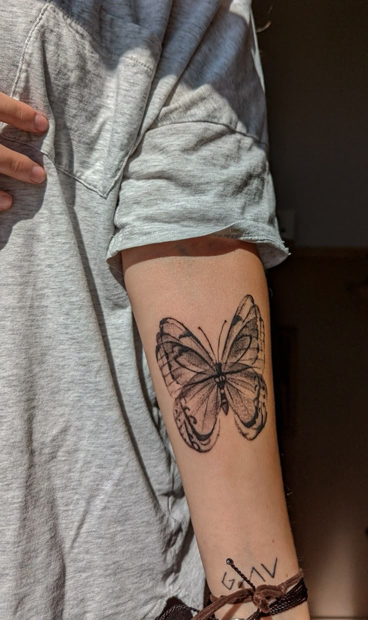 a woman with a butterfly tattoo on her arm