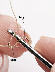 a person holding a pair of scissors in their left hand, with the needle pointed at them