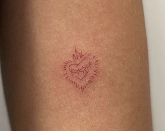 a woman's leg with a tattoo on it that has a heart in the middle