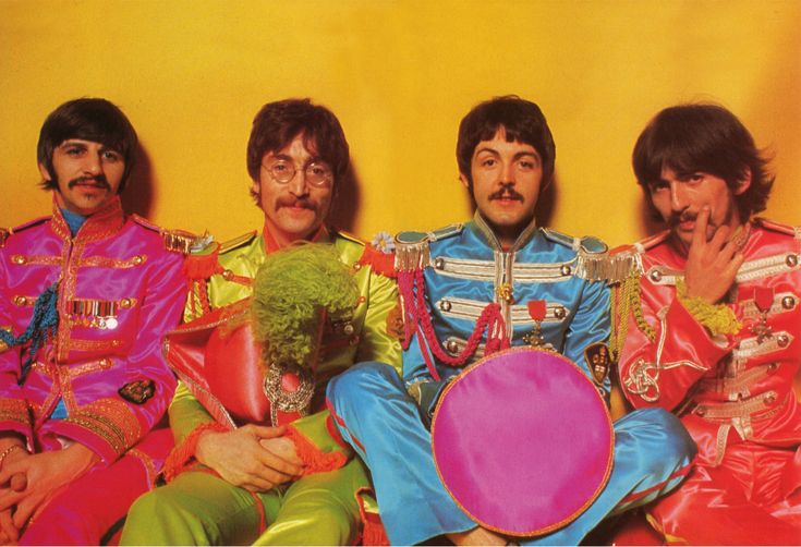 the beatles posing for a photo in their colorful outfits