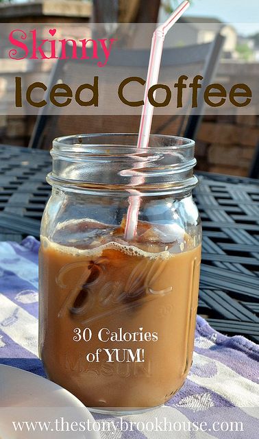 a mason jar filled with iced coffee sitting on top of a blue and white table cloth