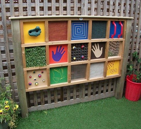 a child's play area with wooden shelves filled with handprints and magnets