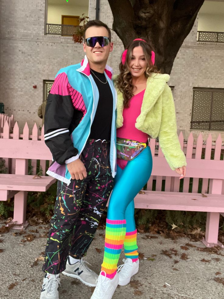 the man and woman are dressed up in colorful outfits, posing for a photo together