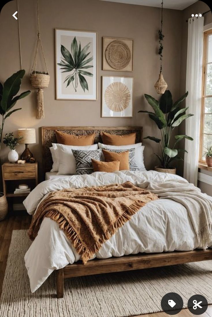 a large bed sitting in a bedroom next to a window with potted plants on it