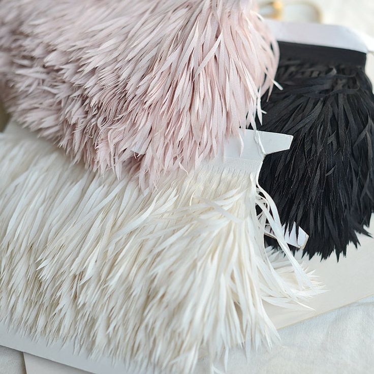 two black and white fur pillows sitting on top of a bed next to each other