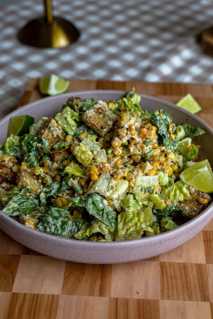 a white bowl filled with salad on top of a wooden table