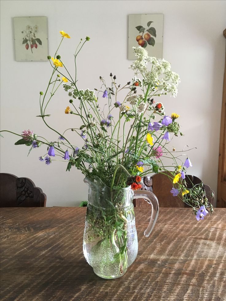 a vase filled with flowers sitting on top of a wooden table