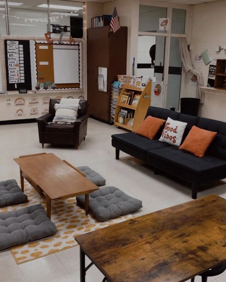 an empty room with couches, tables and chairs in front of the bookshelves