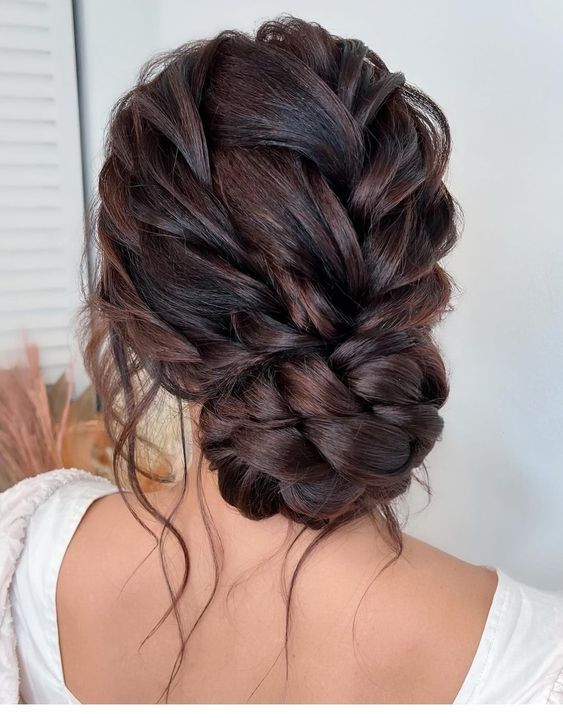 the back of a woman's head with dark brown hair and braid in it