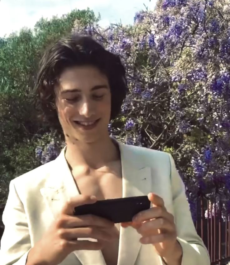 a woman in a white suit holding a cell phone