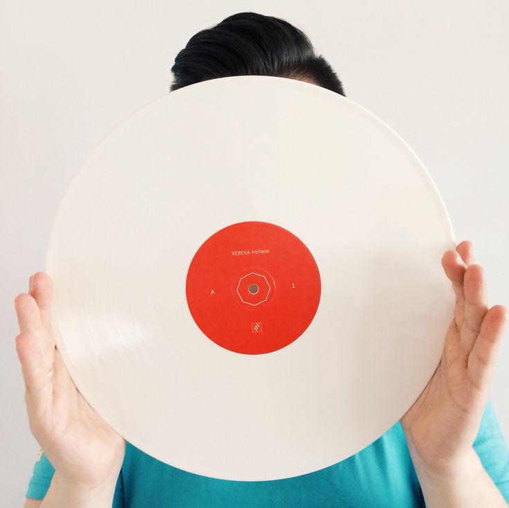 a person holding up a white disk with red dots on the center and bottom part