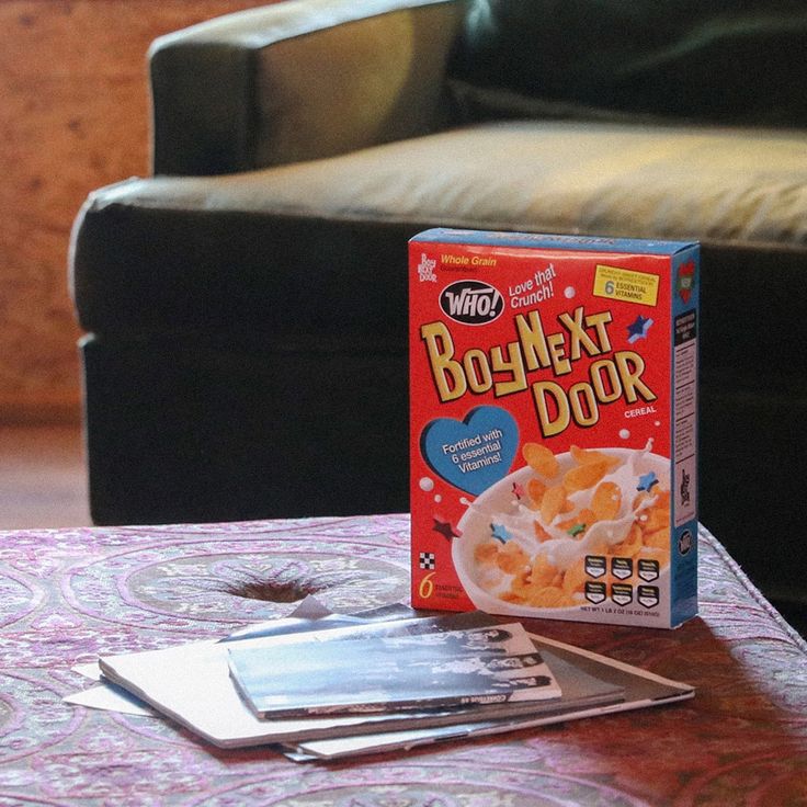 a box of cereal sitting on top of a table next to a wallet and card game