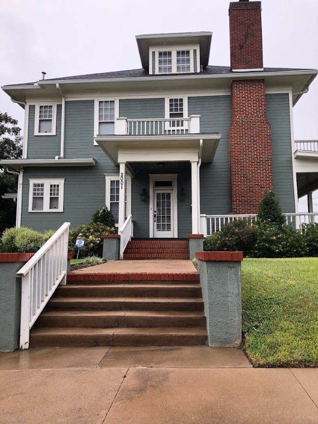 a blue house with stairs leading to the front door