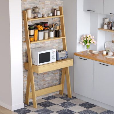 a kitchen area with a microwave, counter and shelves