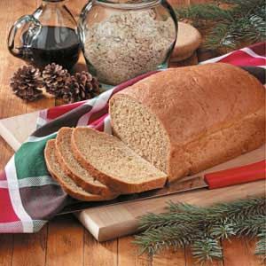 a loaf of bread sitting on top of a cutting board next to some pine cones