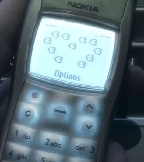 an old nokia cell phone being held in someone's hand with numbers on it