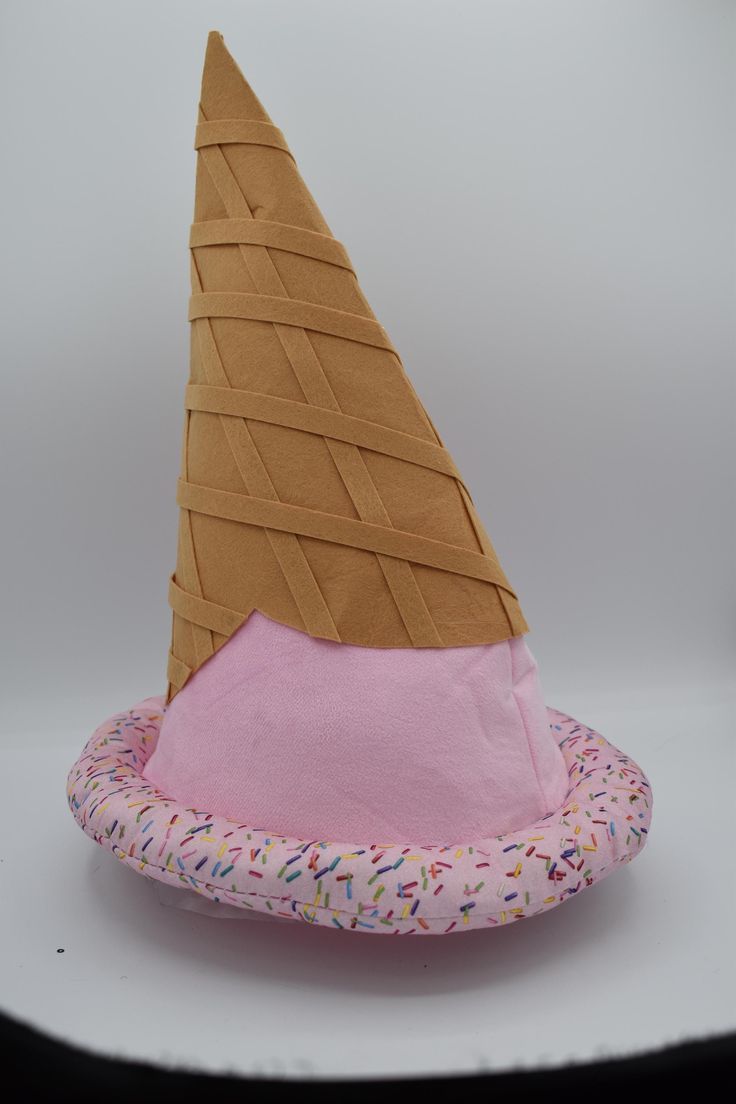 an ice cream cone with sprinkles on it is sitting on a pillow