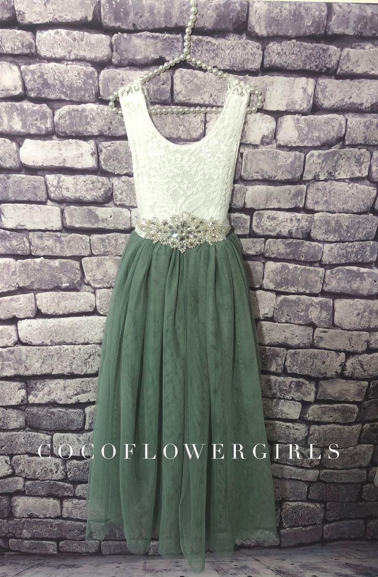 a green and white dress hanging on a brick wall