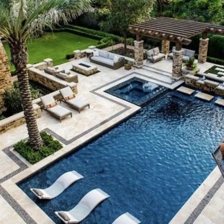 an outdoor swimming pool with lounge chairs and palm trees