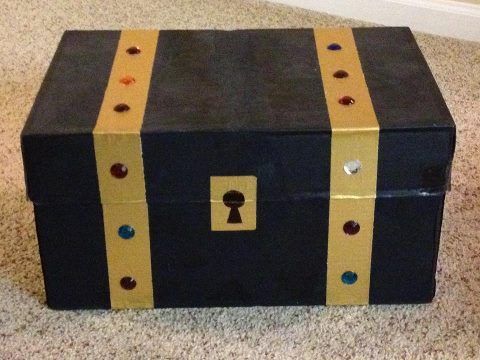 a black and yellow trunk sitting on top of a carpeted floor next to a white wall