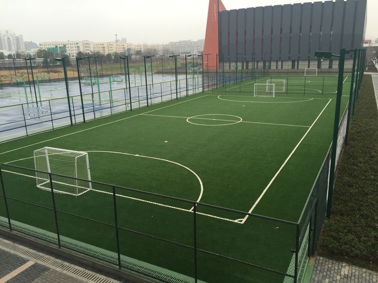 an artificial soccer field in front of a building