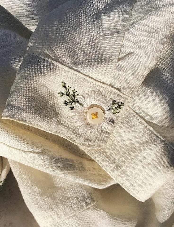 a white shirt with embroidered flowers on it