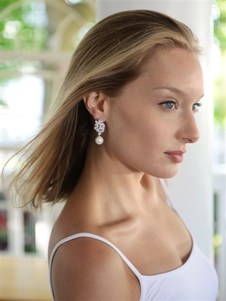 a woman in a white tank top is looking off into the distance