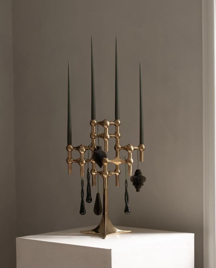 a golden candelabra with black candles on it