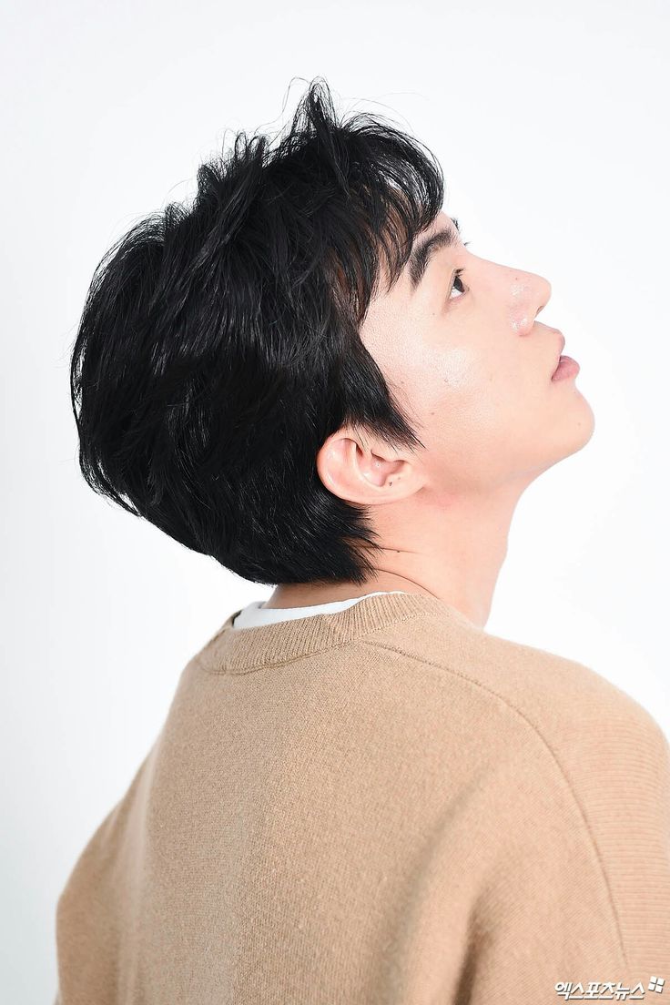 a man with black hair looking up into the sky