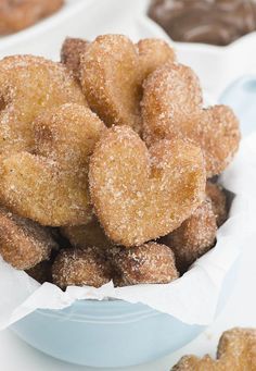 some sugared donuts are in a white bowl