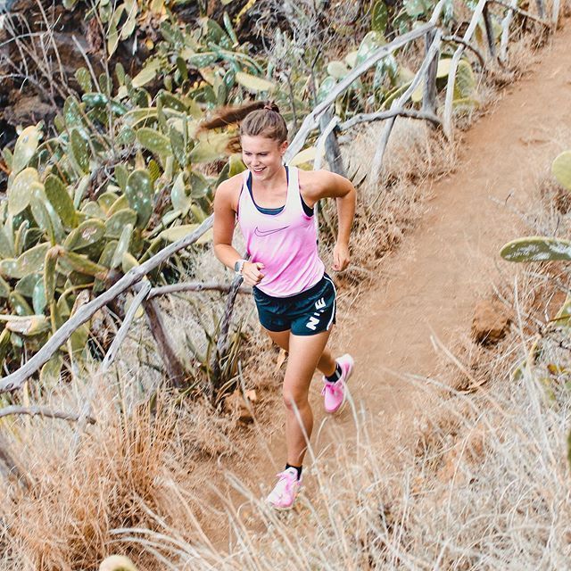 a woman running down a trail in the desert