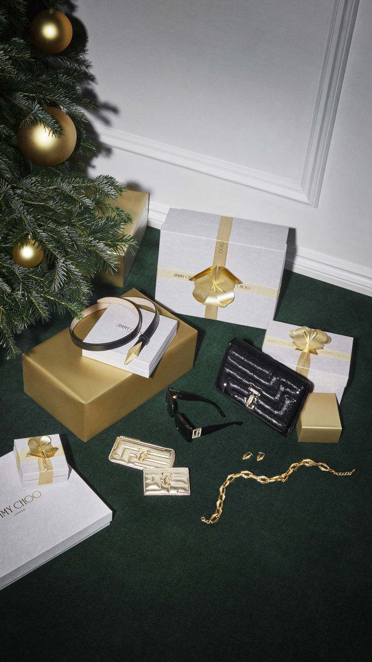 a christmas tree with gold and white presents next to it