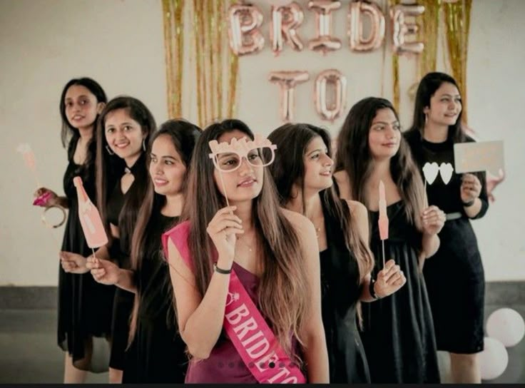 a group of women standing next to each other in front of a sign that says bride to be