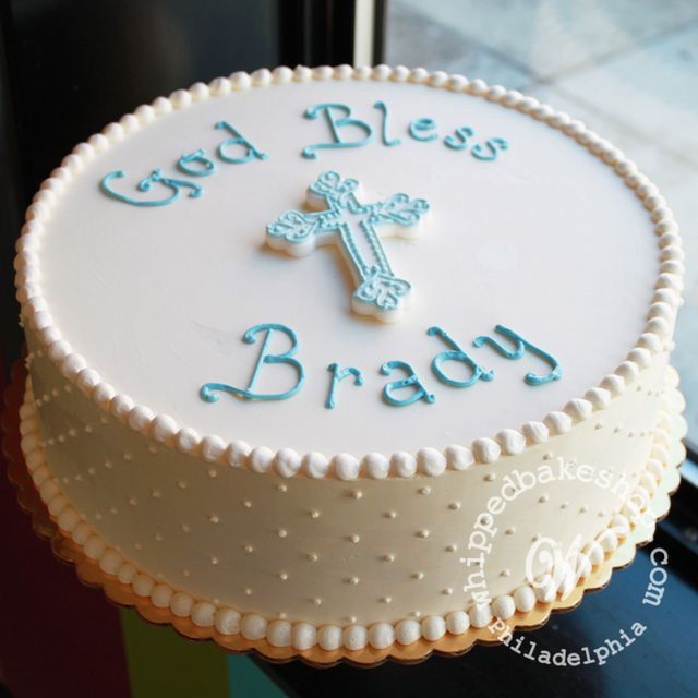 a white cake with blue lettering and a cross on top