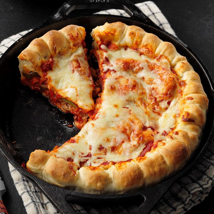 two slices of pizza sitting on top of a skillet with one slice taken out