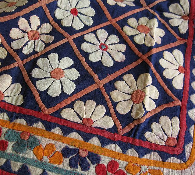 an old quilt with flowers and squares on it