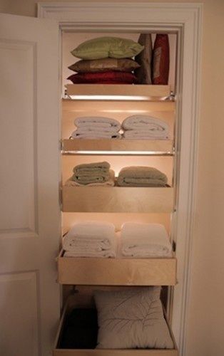 an open closet filled with folded towels and blankets